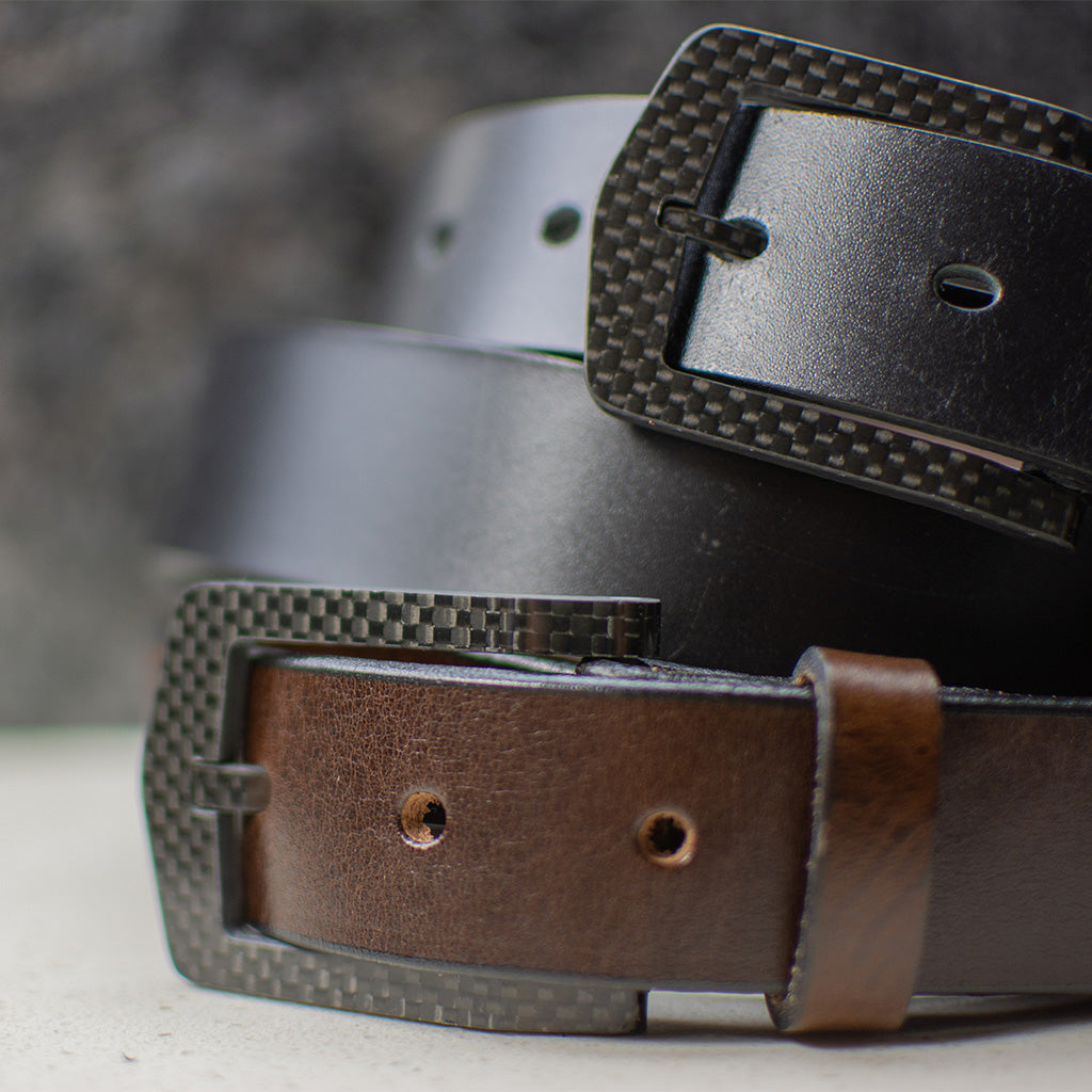 Image of The Stealth Leather Belt Set. Two belts are shown; one brown and one black. They both have black carbon fiber buckles.