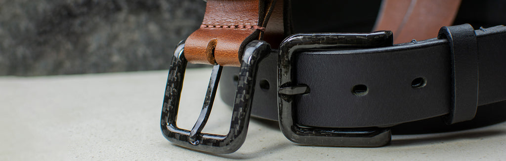 Image of Specialist belt set. Two carbon fiber belts; one brown and one black. Both have a black carbon fiber buckle.