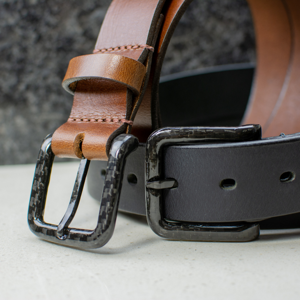 Image of Black and brown leather belts with black carbon fiber buckles sewn on.  Belts have no metal